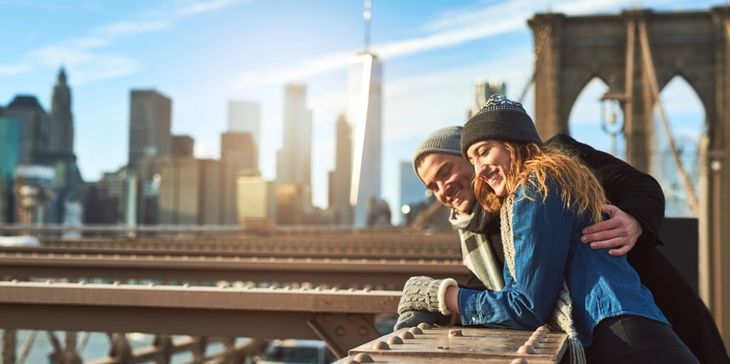 happy couple enjoying views from Brooklyn bridge